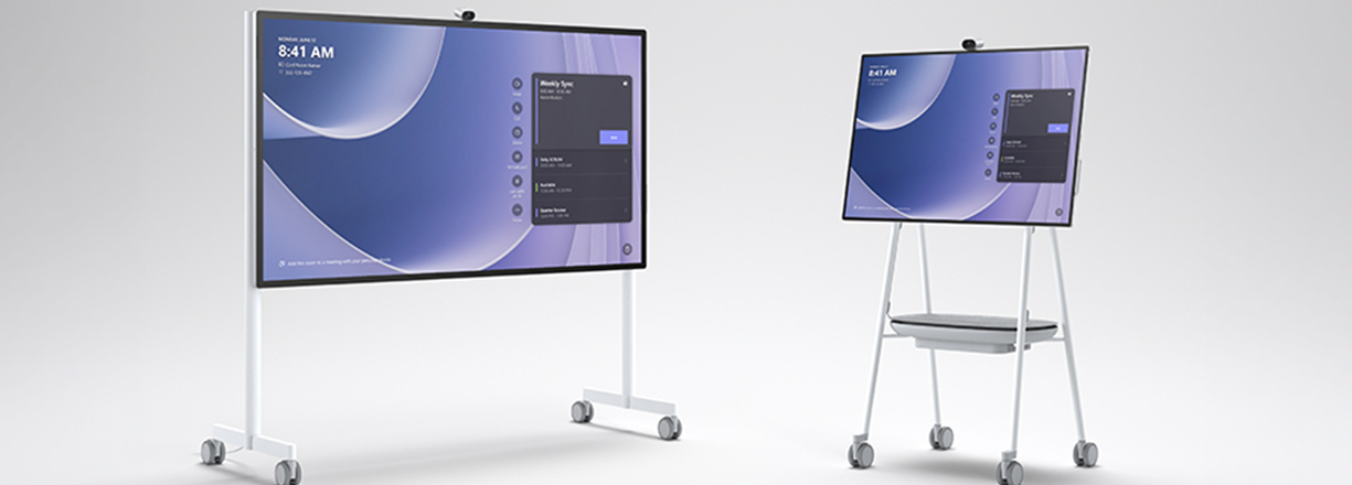 Two Microsoft Surface Hub 3 displays in different sizes on mobile stands with casters, ideal for meetings and collaboration.