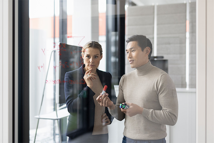 ein Mann und eine Frau schauen gemeinsam auf Notizen