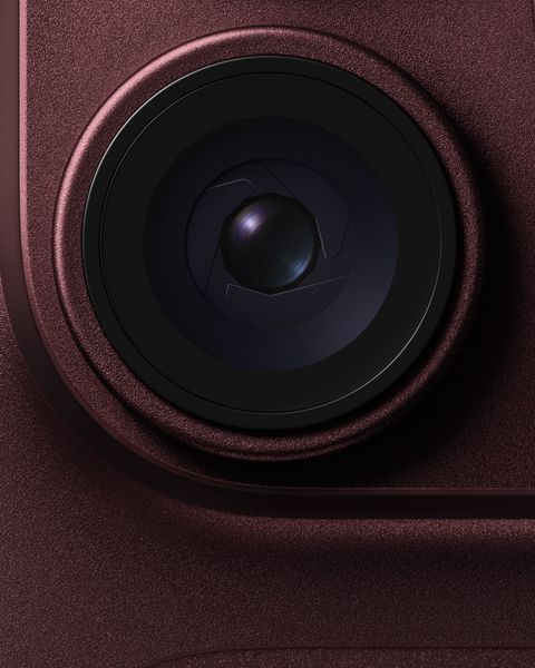 Close-up of a camera lens with metallic red housing for mobile devices