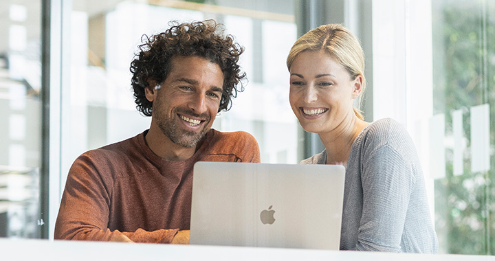 2 People talking in front of MacBook