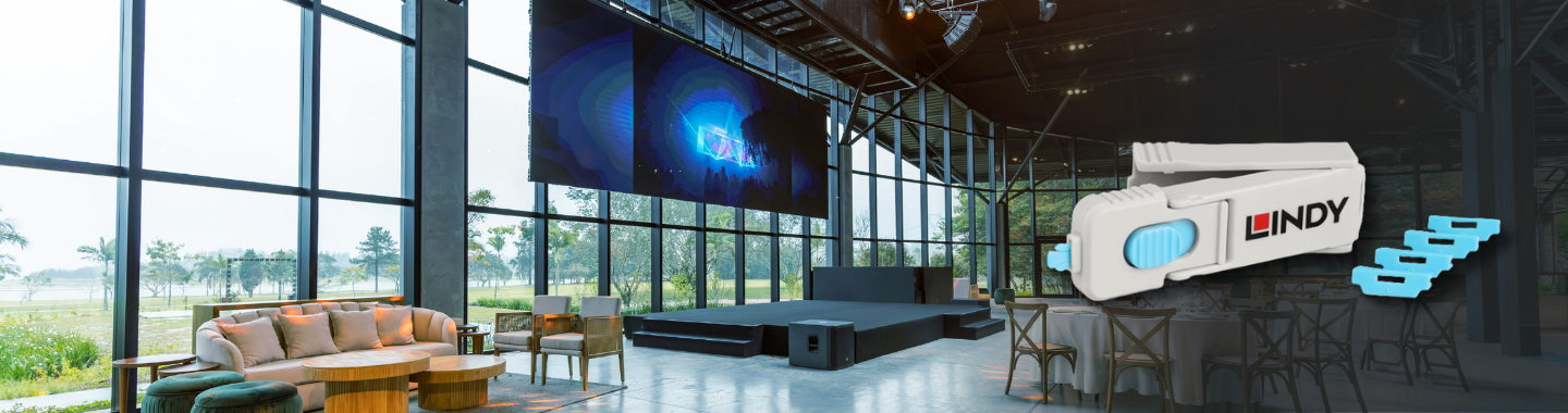 Moderner Veranstaltungsraum mit großer LED-Leinwand und Bühne, dazu ein weißes technisches Gerät von Lindy