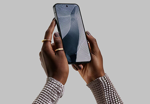 Hands holding a smartphone against a neutral background