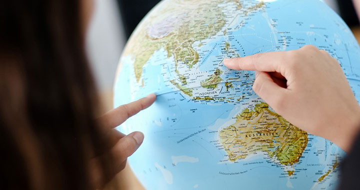 Finger zeigen auf Globus