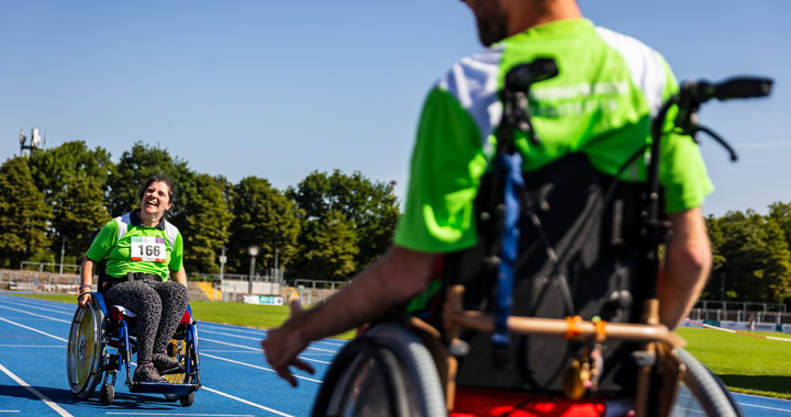 Two wheelchair users on a rubber track