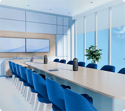 Modern conference room with long table, blue chairs, and video conferencing Owl Labs devices for virtual meetings