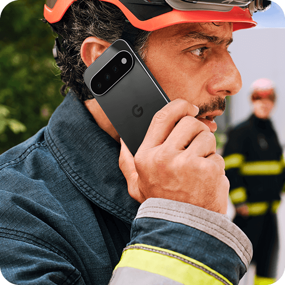 Feuerwehrmann im Einsatz mit Schutzhelm telefoniert mit Smartphone für schnelle Kommunikation