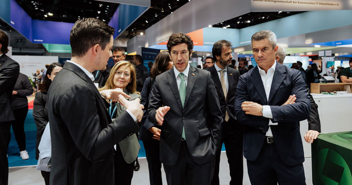 Mehrere Personen im Gespräch auf einer Messe mit Fokus auf Austausch und Networking im Businessumfeld