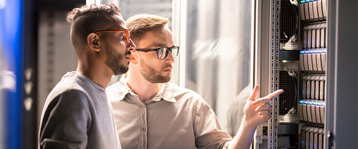 Zwei Männer arbeiten in einem Serverraum.