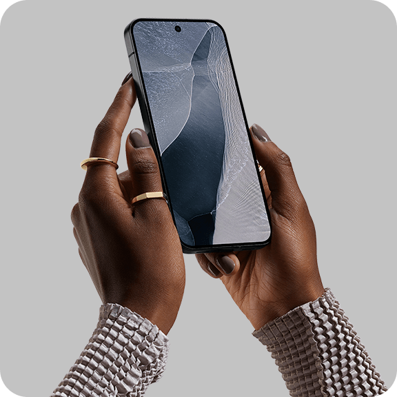 Zwei Hände halten ein Smartphone vor neutralem Hintergrund