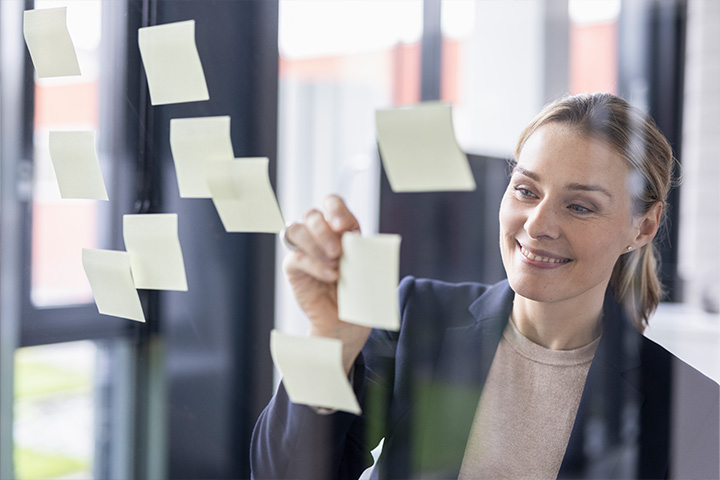 eine Frau sieht sich Klebenotizen an