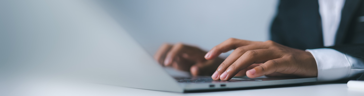 A close-up of hands typing on a laptop