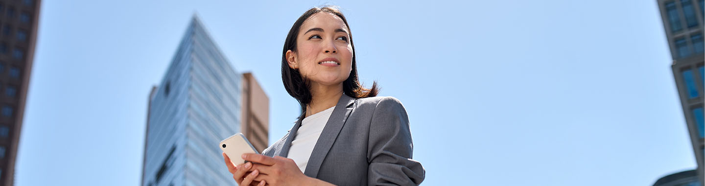 Woman in front of skycrapers with Apple iPhone