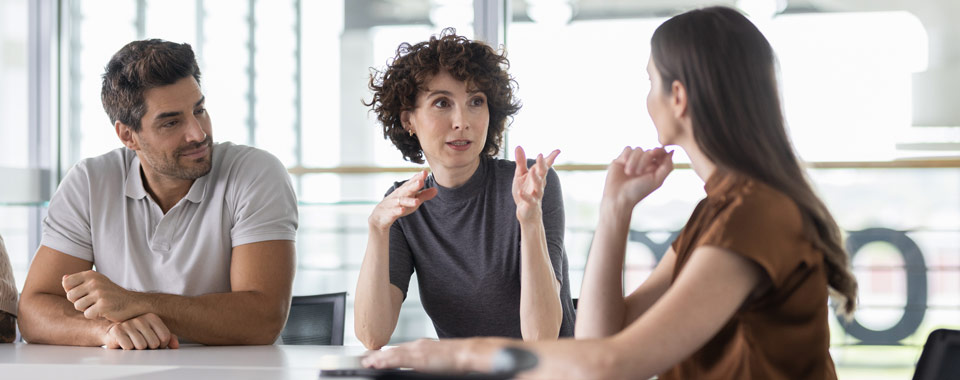 Drei Menschen unterhalten sich im Büro