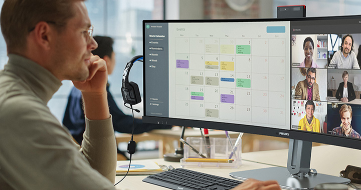 Ein junger Mitarbeiter sitzt vor zwei Monitoren und arbeitet