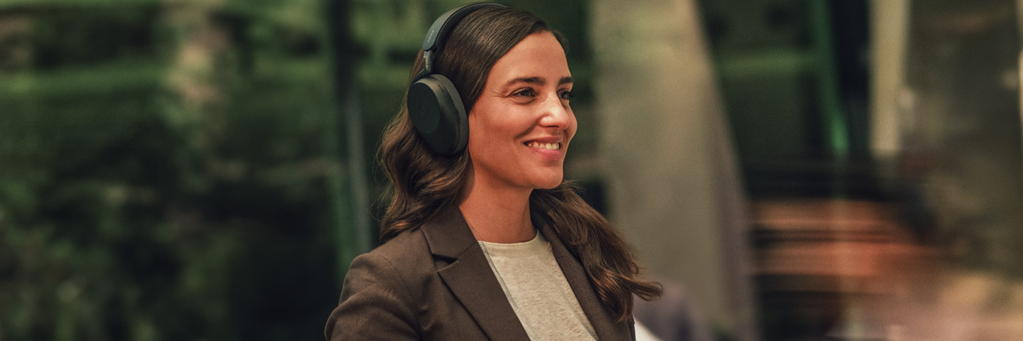 Jabra Audiolösungen. Business Frau läuft glücklich durch die city, während Sie telefoniert mit einem neuen Jabra Headset.