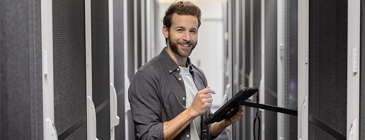 A happy man is working in a server room