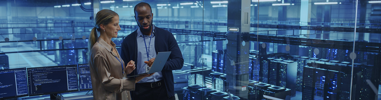 Eine Frau und ein Mann unterhalten sich in einem Serverraum.