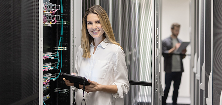 A happy woman is working in a server room