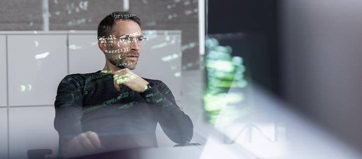 Ein Mann arbeitet an einem Schreibtisch mit einem Code-Nummern-Filter auf dem Bild